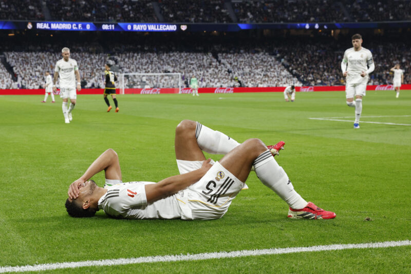 El centrocampista del Real Madrid Jude Bellingham reacciona ante el dolor tras resultar lesionado a los nueve minutos del partido de LaLiga que enfrentó al Real Madrid y al Rayo Vallecano, este domingo, en el Santiago Bernabéu. EFE/ J.J. Guillen
