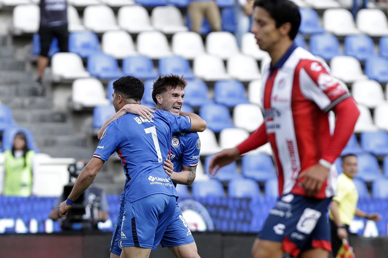 PUEBLA (MÉXICO), 07/03/2026.- Amaury García (i) y Agustín Palavecino (c) de Cruz Azul celebran un gol este sábado, en un partido de la jornada 10 del torneo Clausura 2026 de la Liga MX, en el estadio Cuauhtémoc en Puebla (México). EFE/ Hilda Ríos