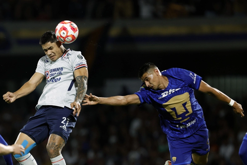 CIUDAD DE MÉXICO (MÉXICO), 14/03/2026.- Guillermo Martínez (i) de Pumas disputa un balón con Gabriel Fernández (i) de Cruz Azul este sábado, durante un partido del torneo Clausura 2026 de la Liga MX entre Pumas y Cruz Azul en el estadio Olímpico Universitario en Ciudad de México (México). EFE/Sáshenka Gutiérrez