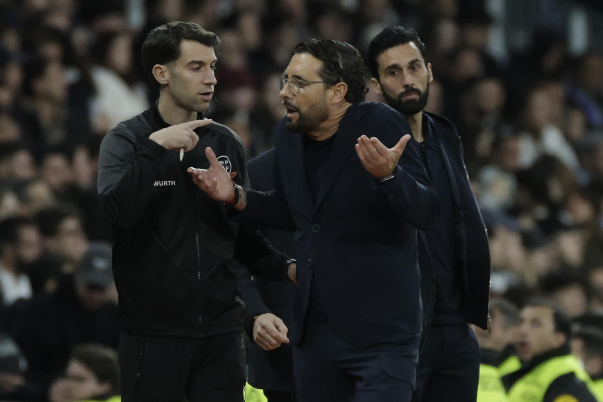 El entrenador del Getafe, José Bordalás (c), conversa con el cuarto árbitro durante el partido de LaLiga contra el Real Madrid. EFE/Juanjo Martín