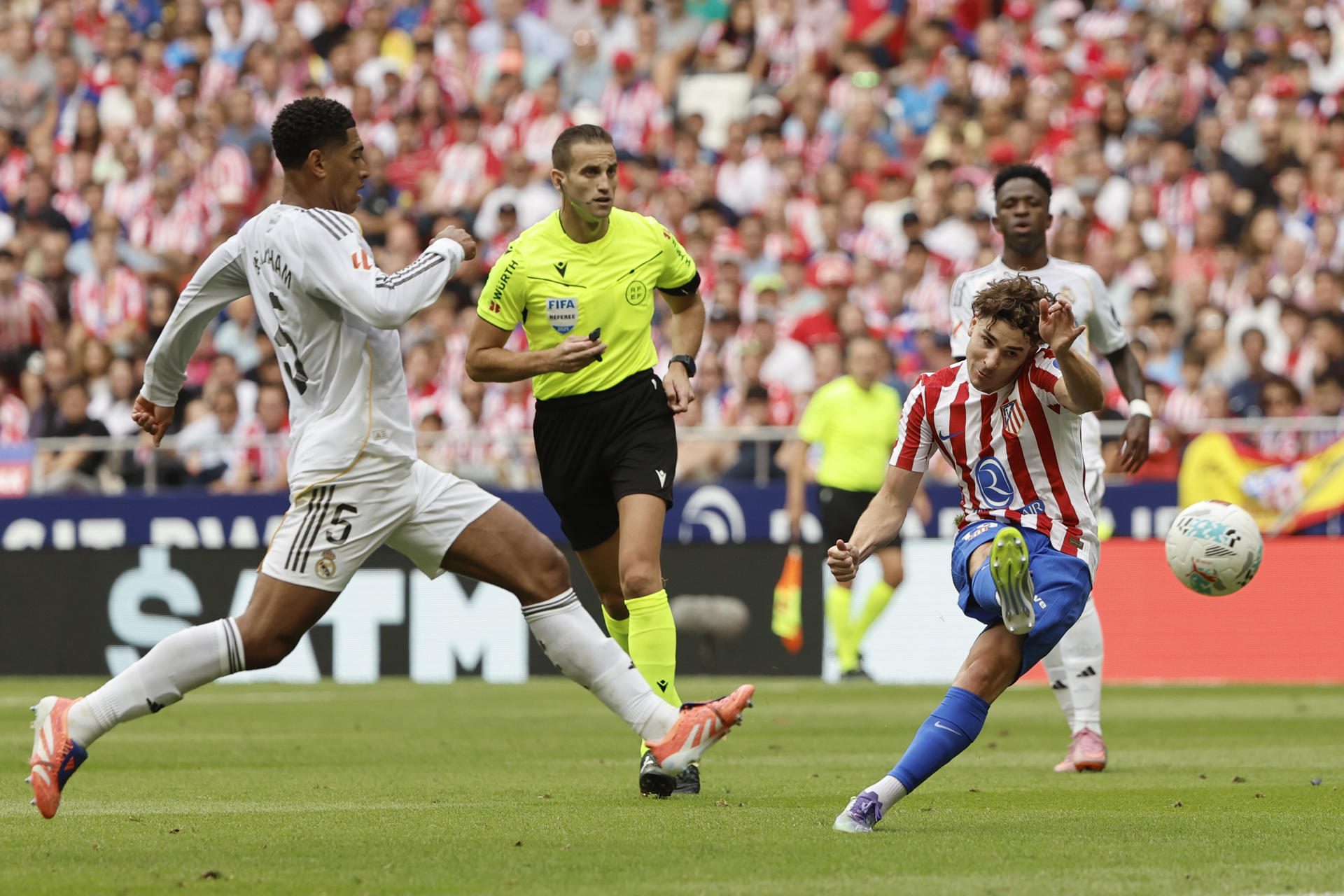 Fotografía de archivo del delantero del Atlético de Madrid Julián Álvarez (d) en la que dispara a puerta ante Jude Bellingham, del Real Madrid, durante el partido de liga entre el Real Madrid y el Atlético de Madrid que se disputó en el estadio Riyadh Air Metropolitano. EFE/Sergio Pérez