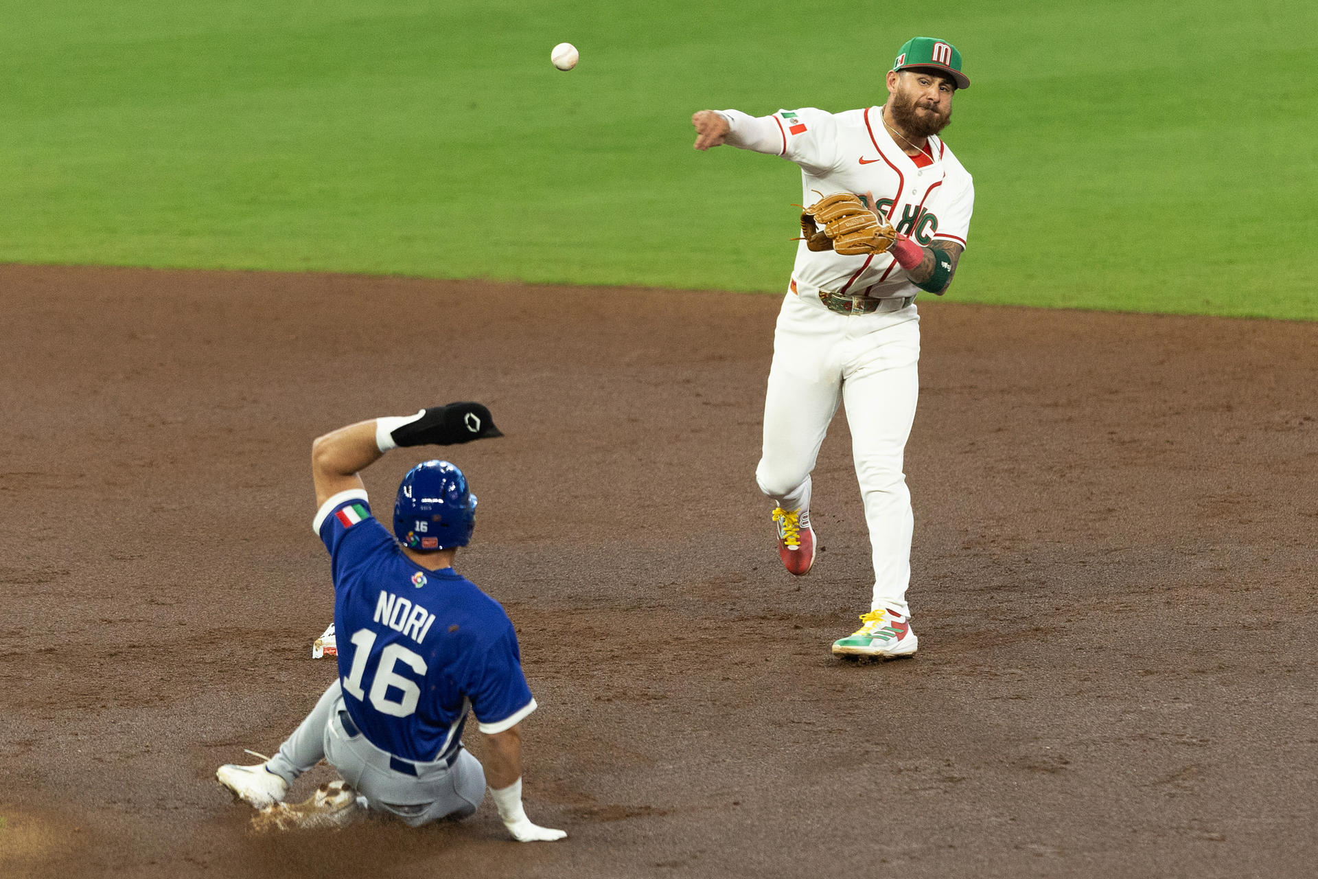 Nick Gonzales (d), de México, realiza un lanzamiento frente a Dante Nori, de Italia, en un partido del Clásico Mundial de Béisbol entre México e Italia en el estadio Daikin Park, en Houston (Estados Unidos). EFE/Carlos Ramírez