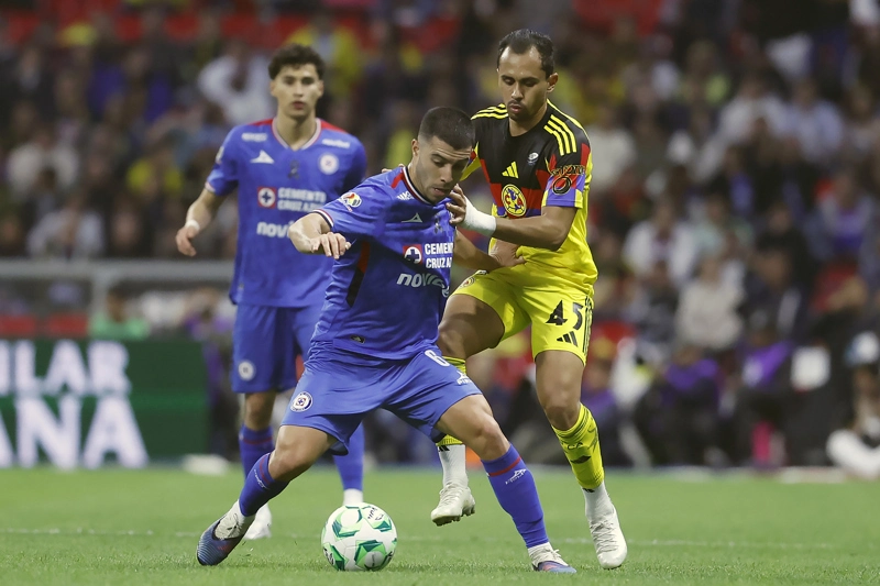 CIUDAD DE MÉXICO (MÉXICO), 11/04/2026.- Vinícius Moreira (i) de América disputa el balón con Erik Lira (d) de Cruz Azul este sábado, en un partido de la jornada 14 del torneo apertura 2026 de la Liga MX entre América y Cruz Azul en el estadio Banorte en Ciudad de México (México). EFE/ Sáshenka Gutiérrez