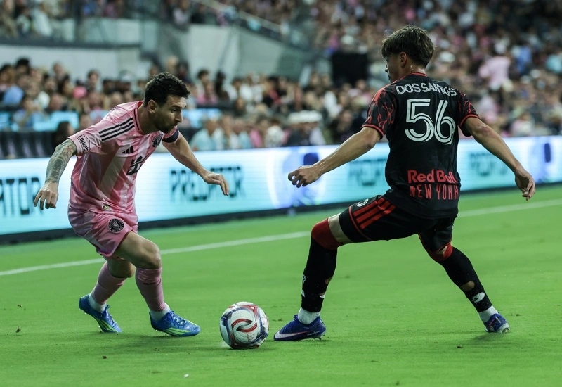 MIAMI (Estados Unidos), 11/04/2026.- El centrocampista ofensivo del Inter Miami CF, Lionel Messi (derecha), en acción contra el lateral izquierdo de los New York Red Bulls, Matthew Dos Santos, durante el partido de la MLS entre el Inter Miami CF y el Red Bull New York en el Nu Stadium en Miami, Florida, el 11 de abril de 2026. (Nueva York) EFE/EPA/CRISTOBAL HERRERA-ULASHKEVICH