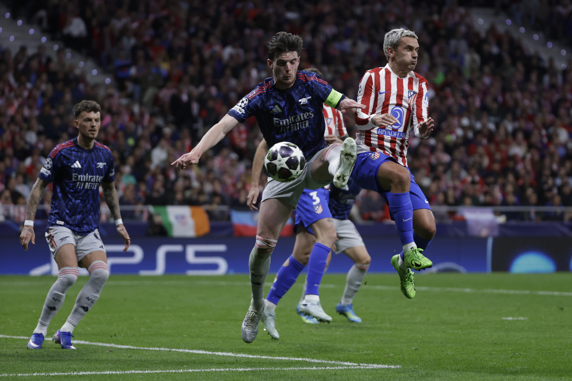 El delantero del Atlético de Madrid Antoine Griezmann (d) disputa un balón con el centrocampista del Arsenal Declan Rice (c) durante el encuentro correspondiente a la ida de las semifinales de la Liga de Campeones que Atlético de Madrid y Arsenal disputaron en el estadio Metropolitano, en Madrid. EFE/Juanjo Martín