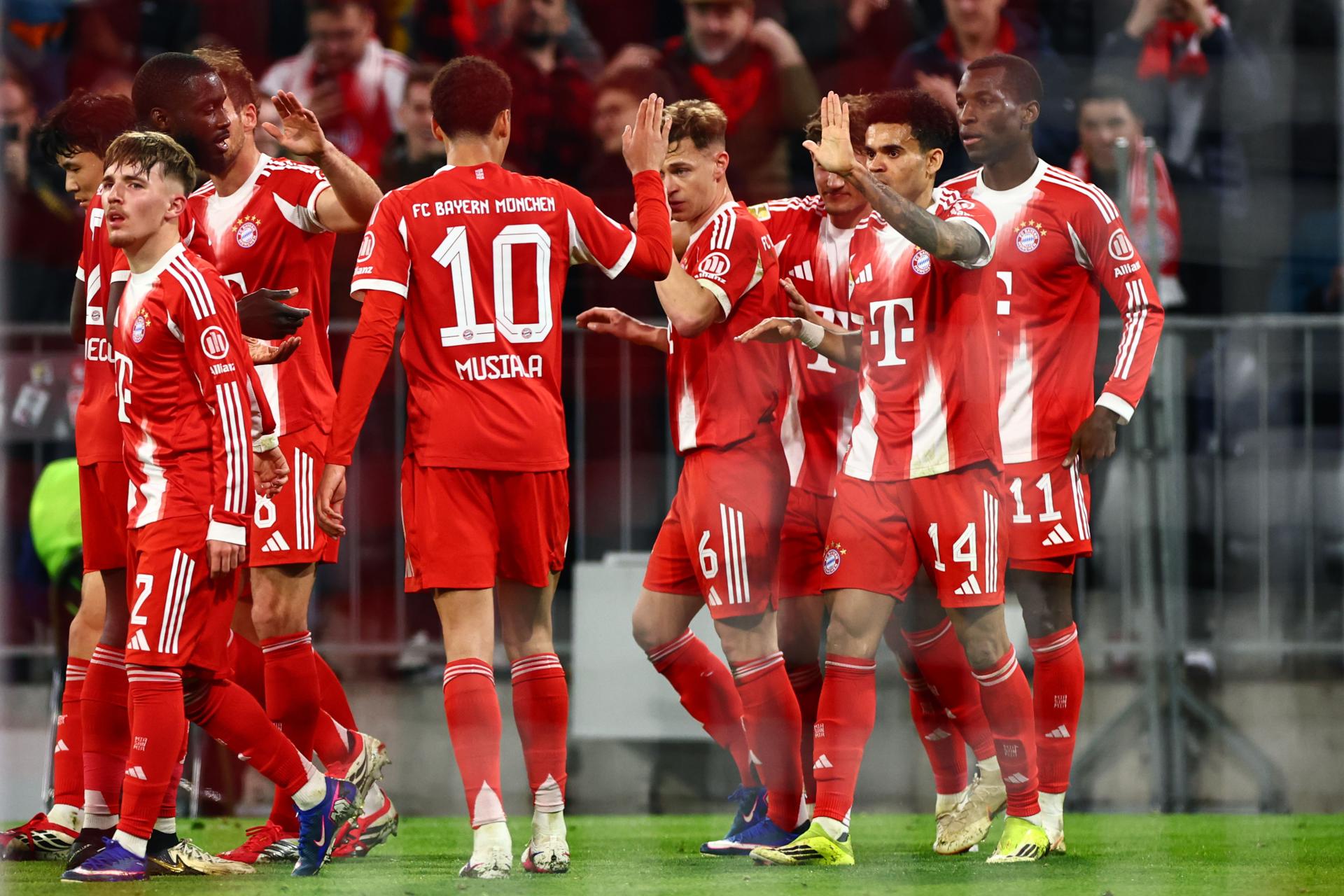 Jamal Musiala felicita a Luis Díaz, tras marcar un gol con l Bayern Múnich. EFE/EPA/ANNA SZILAGYI