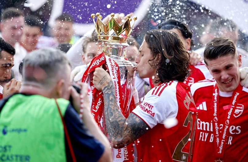 LONDRES (Reino Unido), 24/05/2026.- El jugador del Arsenal Riccardo Calafiori (C) besa el trofeo de la Premier League mientras celebra junto a sus compañeros al final del partido de la Premier League inglesa entre el Crystal Palace y el Arsenal FC, en Londres, Reino Unido, el 24 de mayo de 2026. Es el primer título de la Premier League del Arsenal en 22 años. (Reino Unido, Londres) EFE/EPA/TOLGA AKME ligas europeas