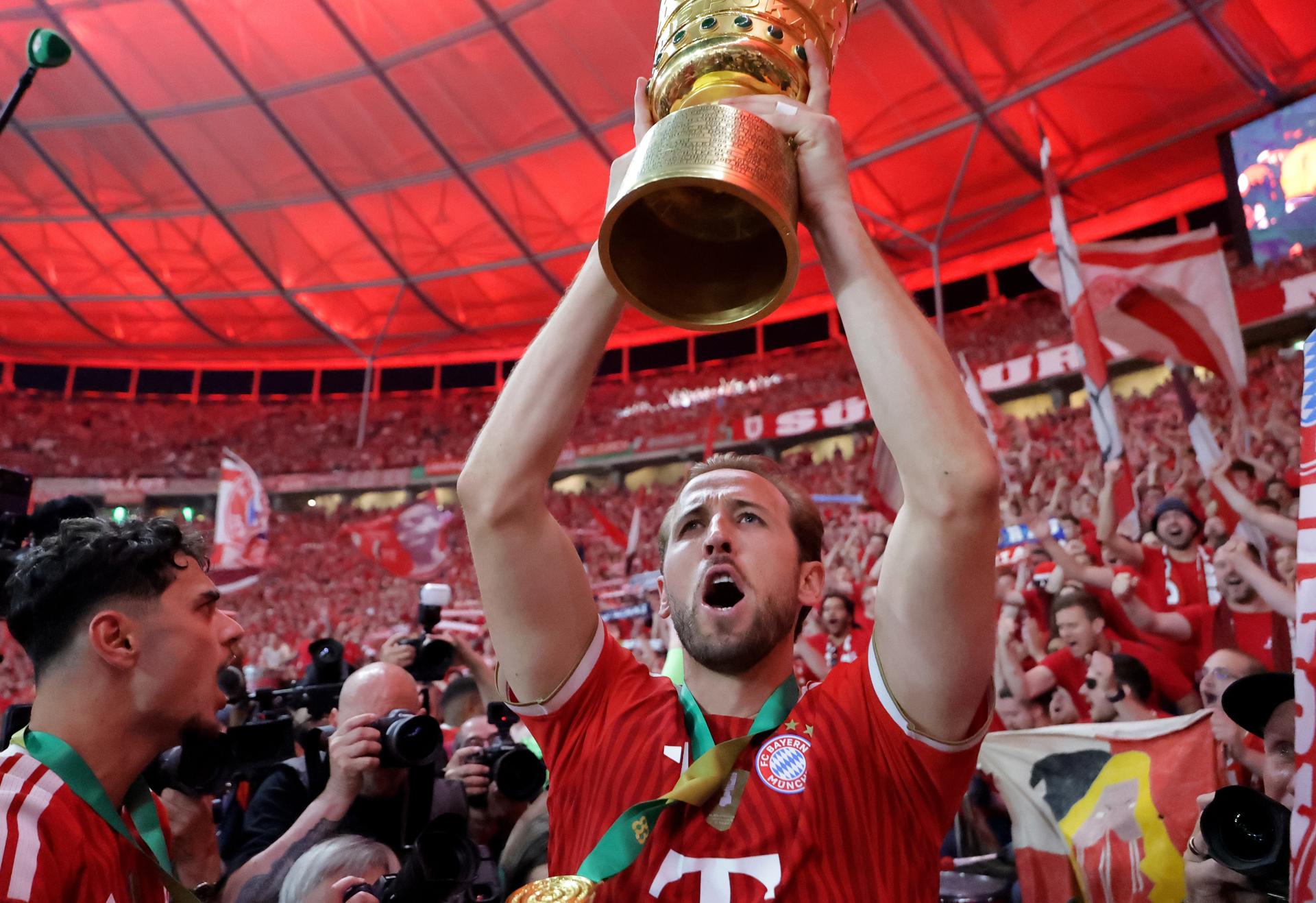 El futbolista inglés Harry Kane, del Bayern Múnich, levanta el trofeo de la Copa de Alemania este sábado, tras vencer al VfB Stuttgart. EFE/CHRISTOPHER NEUNDORF
