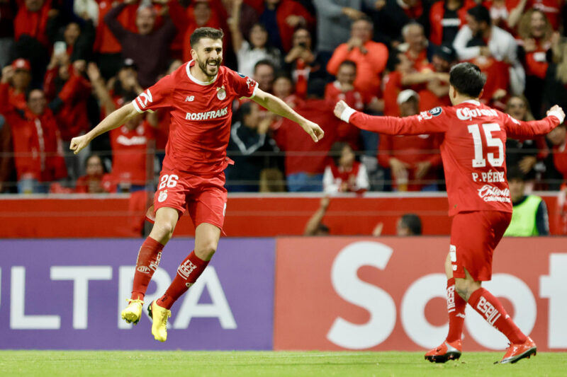 Joao Dias (i) y Pavel Pérez del Toluca celebran un gol este miércoles, durante un partido de la semifinal de la Copa de Campeones Concacaf en el estadio Nemesio Diez en Toluca (México). EFE/Felipe Gutiérrez