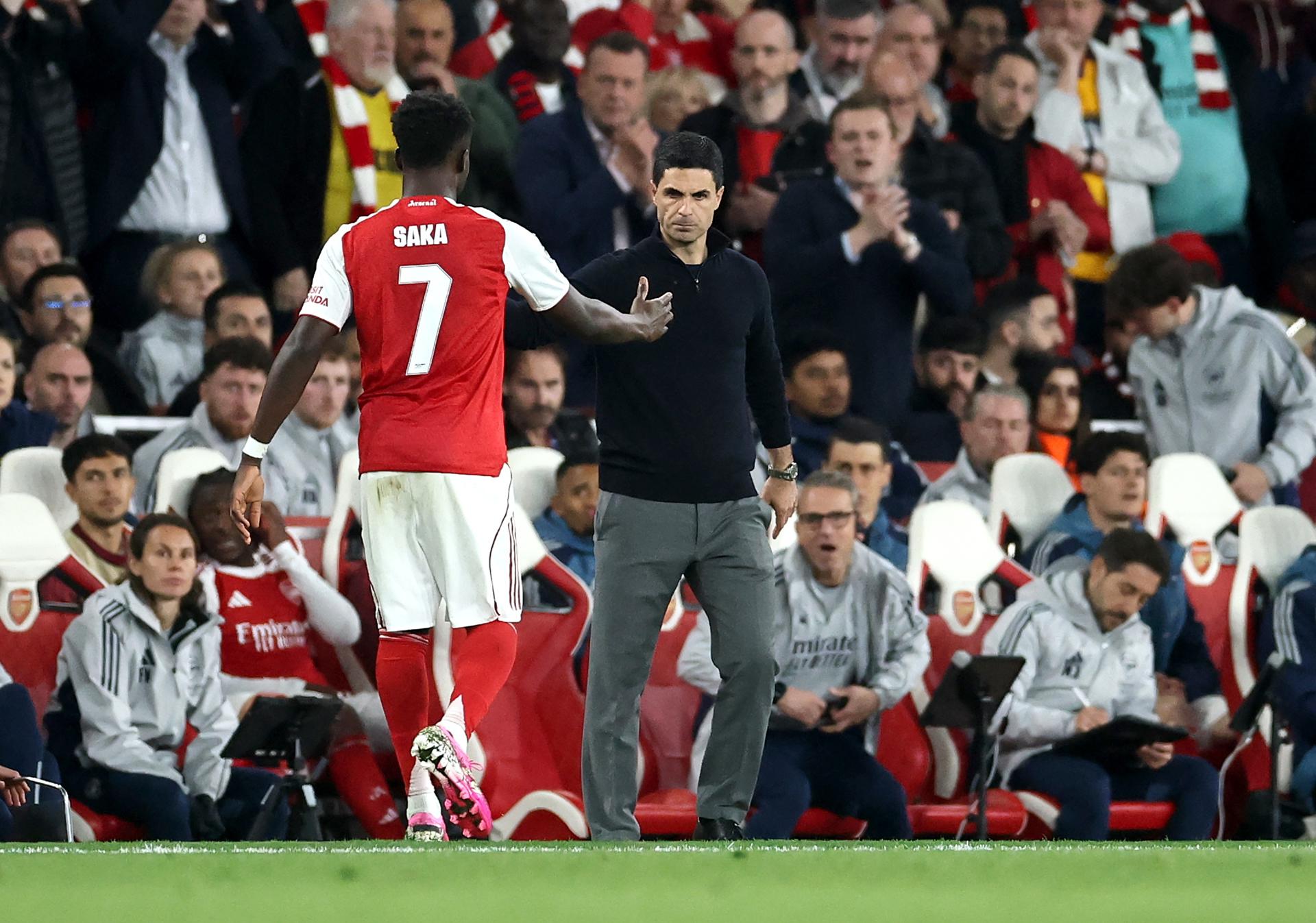 El jugador del Arsenal Bukayo Saka (I) saluda a su entrenador Mikel Arteta al ser sustituido durante el partido de la vuelta de semifinales de la UEFA Champions League que han jugado Arsenal FC y Atletico de Madrid, en Londres, Reino Unido. EFE/EPA/NEIL HALL