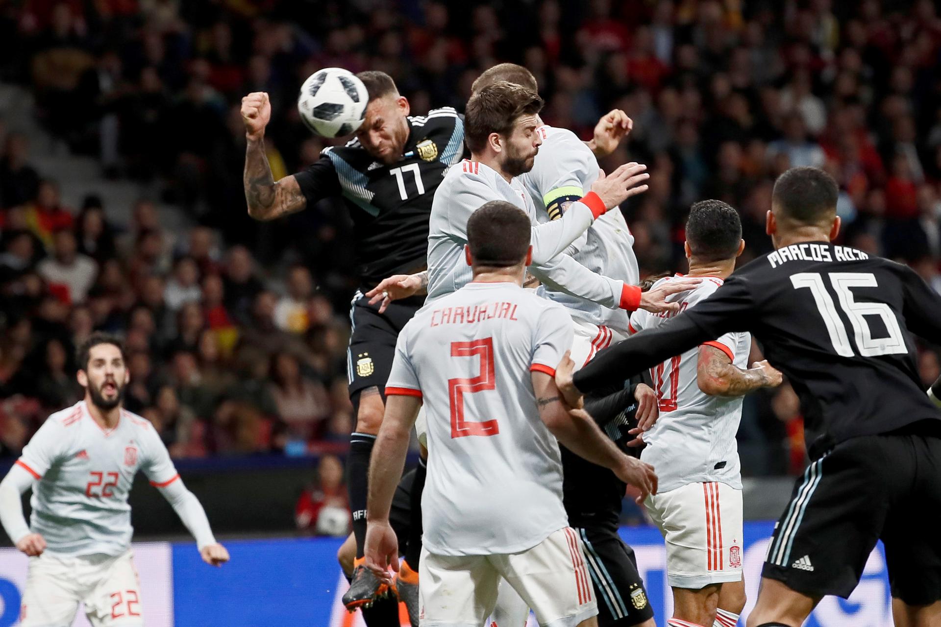 Fotografía de archivo del 27 de marzo de 2018, en la que puede verse al defensa de la selección argentina Otamendi (i) remata para marcar ante España, durante el partido amistoso disputado en el Estadio Wanda Metropolitano, en Madrid. EFE/Mariscal