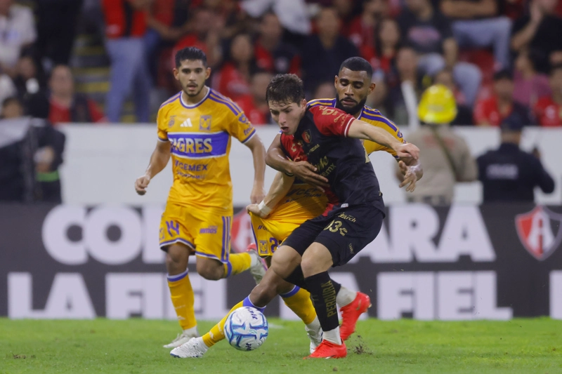 GUADALAJARA (MÉXICO), 15/08/2026.- José Martín (d) de Atlas disputa el balón con Joaquim Pereira de Tigres este sábado, en un partido de la Liga MX entre Atlas y Tigres en el estadio Jalisco, en Guadalajara (México). EFE/ Francisco Guasco